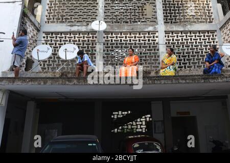 Colombo, Sri Lanka. April 2020. Menschen, die während der Aufführung auf sozialer Distanz zueinander beobachten.Mitglieder der Musikkapelle der Polizei Sri Lankas treten auf, um die Moral der Menschen im Kampf gegen die Verbreitung des SARS-COV-2-Coronavirus zu steigern. Credit: SOPA Images Limited/Alamy Live News Stockfoto