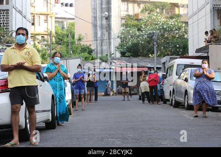 Colombo, Sri Lanka. April 2020. Menschen, die während der Aufführung auf sozialer Distanz zueinander beobachten.Mitglieder der Musikkapelle der Polizei Sri Lankas treten auf, um die Moral der Menschen im Kampf gegen die Verbreitung des SARS-COV-2-Coronavirus zu steigern. Credit: SOPA Images Limited/Alamy Live News Stockfoto