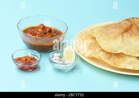 Indisches Gericht würziger Chick Peas Curry auch bekannt als Chole Bhatura und Chana Masala, traditionelles nordindisches Mittagessen serviert mit gebratenem puri oder Fladenbrot Stockfoto