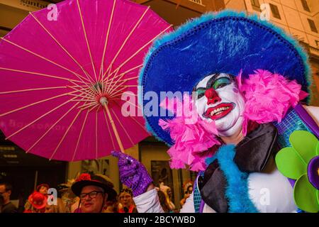 Eine Frau, verkleidet und als Clown bemalt, feiert tagsüber auf den Straßen den Karneval Stockfoto