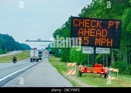 Ein elektronisches Schild auf der Interstate 10 East warnt Autofahrer bei der COVID-19-Pandemie vor einem Polizeikontrollpunkt in der Nähe der Florida State Line. Stockfoto