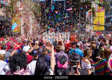 Massen von verkleideten Menschen feiern in den Straßen vor einer großen Bühne während des Tages Karneval Stockfoto