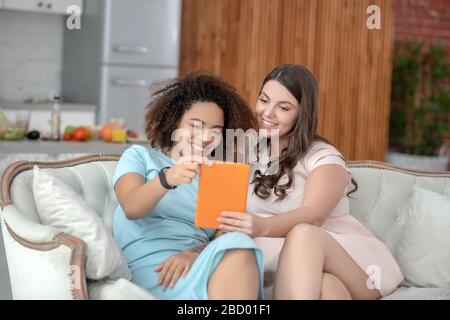 Zwei junge Freundinnen nehmen selfie zu Hause auf Tablet. Stockfoto