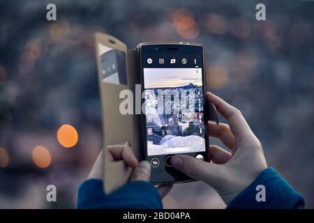 Reisende Frau, die sich bei der Dämmerung auf ihrem Handy in Kappadokien in der Türkei von der Burg Uchisar fotografiert Stockfoto