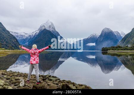 Junge asiatische Reisende feiern Erfolg im Milford Sound, Fiordland National Park, South Island, Neuseeland Stockfoto