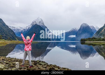 Junge asiatische Reisende feiern Erfolg im Milford Sound, Fiordland National Park, South Island, Neuseeland Stockfoto