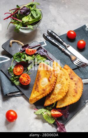 Lateinamerikanische, mexikanische und chilenische Küche. Traditionelle Backwaren Empanadas mit Rindfleisch auf Betongrund Stockfoto