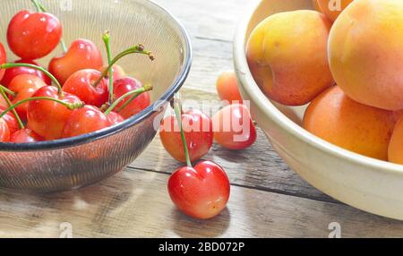 Frisches Obst Kirschen und Aprikosen auf einem Holztisch. Stockfoto