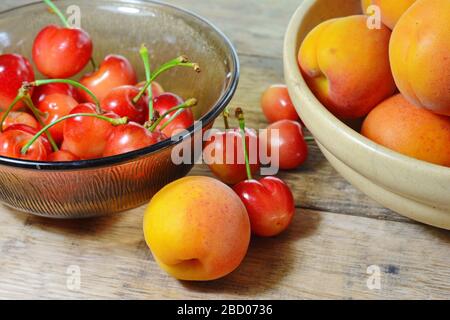 Frisches Obst Kirschen und Aprikosen auf einem Holztisch. Stockfoto