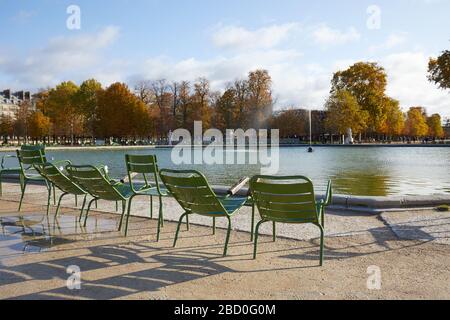 PARIS - 7. NOVEMBER 2019: Tuileries Garten mit grünen Metallstühlen und Springbrunnen an einem sonnigen Herbsttag in Paris Stockfoto