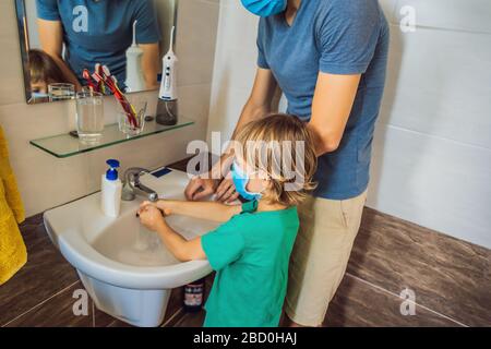 Vater lehrt seinen Sohn, seine Hände richtig zu waschen. Vater und Sohn in medizinischen Masken wegen Coronoviren. Epidemie. Bleiben Sie zu Hause. Waschen Sie Ihre Hände Stockfoto