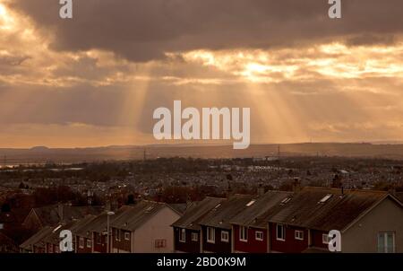 East Edinburgh, Schottland, Großbritannien. April 2020. Gottes Strahlen erleuchten den ansonsten trüben Himmel in Richtung East Lothian. Gottesstrahlen entstehen, wenn ein Raum eine dichte Mischung von Lichtstreumedien wie Gasmolekülen und Objekten enthält, die das Licht verschließen, so dass Schattenvolumina entstehen, die scheinbar Lichtstrahlen erzeugen, die von der Lichtquelle ausgehen. Temperatur ein mildes 10 Grad Celsius. Credit: Arch White/Alamy Live News. Stockfoto