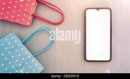 Flacher Lay Draufsicht auf Smartphone- und Papiertaschen Online-Shopping und Heimzustellkonzept Mockup Stockfoto