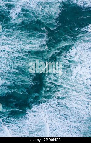 Blue foamy ocean waves and sand aerial drone top view Stockfoto