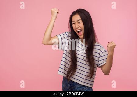 Porträt eines euphorisch fröhlichen Mädchens mit langen Haaren, die mit Glück schreien und die Hände in Geste erheben Ja, Hurray, ich habe es getan und den Sieg gefeiert Stockfoto