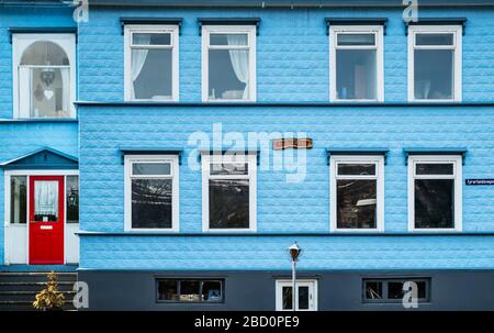 Ein altes Holzhaus in Akureyri, Island. Die Wände sind mit blau lackierten Metallfliesen, bekannt als Steinziegel, bedeckt Stockfoto