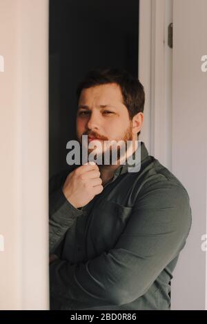 Porträt des jungen europäischen Mannes, der in der Nähe der Tür steht. Stockfoto