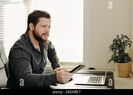 Finanzanalyst arbeitet mit Matrphone und Laptop. Stockfoto