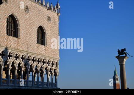 Venedig, Italien-Februar 2020; niedrige Winkelansicht eines Teils der Fassade des Dogenpalastes auf dem Markusplatz mit San Giorgo Maggiore im Hintergrund Stockfoto