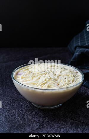 Profiteroles mit weißer Schokolade in Glasküssel. Boutiqe-Dessert aus der lokalen Patisserie. Stockfoto