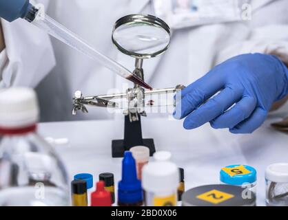 Spezialisierte Polizei unter zeigt Blut im Mikroskop Halterung im wissenschaftlichen Labor zu analysieren, konzeptionell Bild Stockfoto