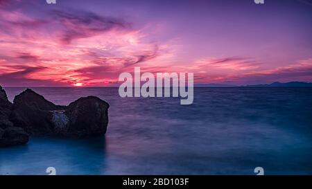 Lange Belichtung photograhy am felsigen Kato Petres Strand Landschaft in der Abenddämmerung. Rhodos, Griechenland Stockfoto