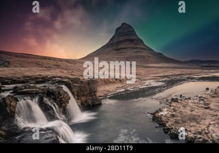 Nordlichter aurora borealis über dem Wasserfall Kirkjufell in Island Stockfoto