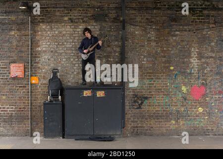 Busker spielt Gitarre, Chalk Farm Road, Camden Town, London, Großbritannien Stockfoto