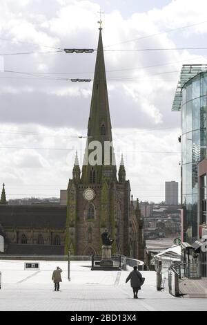 Birmingham, West Midlands, Großbritannien. April 2020. Zwei Personen, die durch ein fast leeres Bullring-Einkaufszentrum in Richtung St. Martin's Church laufen, während die Einwohner von Birmingham den Rat der Regierung bekamen, sich nicht mit unnötigen Aktivitäten am Montagmorgen zu beschäftigen. Die Straßen sind fast leer, selbst im Stadtzentrum. Die Straßen waren leer von Leben und die wenigen Fußgänger, die draußen waren, waren korrekt soziale Distanz. Ein Mann ging die verlassene New Street hinunter mit 2 vollen Taschen voller Einkäufe in einer der meist geschäftigsten Straßen von Birmingham. Stopp Drücken Sie Med Stockfoto