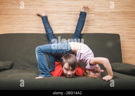 Geschwister, die die Wände klettern, steckten im eigenen Heim in Selbstisolation fest. Quarantäne und Sperrung von Schutzmaßnahmen gegen die Ausbreitung von Coronavi Stockfoto