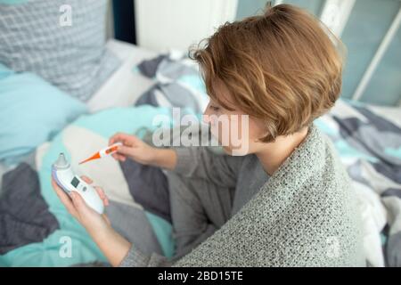 Junges Mädchen hat zu Hause ein kältes, junges Mädchen im Bett erwischt Stockfoto