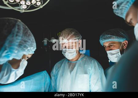 Der leitende Chirurg im Operationssaal, wo der Patient auf ihn wartet, und er beginnt mit der Operation. Real modern Hospital mit authentischem Ambiente Stockfoto