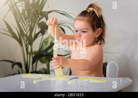 Kleines Mädchen spielt zuhause mit Slime. Kreatives Motorspiel für Kinder. Quarantäne-Kovid-19-Idee. Stockfoto