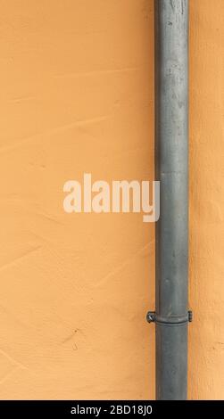 Regenwasserleitung. Abwassersystem. Rohre an der Fassade des Gebäudes. Haus nach der Renovierung. Metallkonstruktionen. Raue Oberflächen. Stockfoto