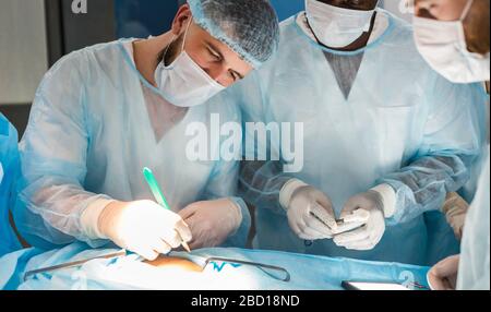 Der leitende Chirurg im Operationssaal, wo der Patient auf ihn wartet, und er beginnt mit der Operation. Real modern Hospital mit authentischem Ambiente Stockfoto