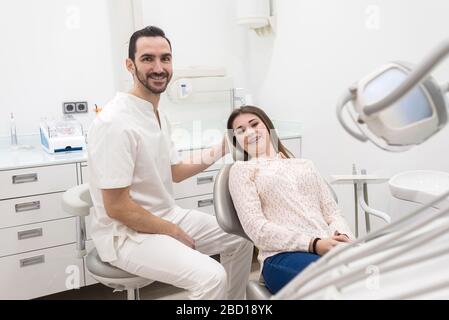 Porträt eines männlichen bärtigen Zahnarztes und junger glücklicher weiblicher Patient. Stockfoto