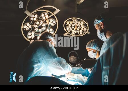 Der leitende Chirurg im Operationssaal, wo der Patient auf ihn wartet, und er beginnt mit der Operation. Real modern Hospital mit authentischem Ambiente Stockfoto