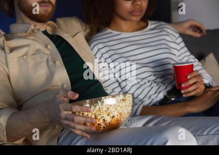 Zugeschnittenes Porträt eines modernen Mixed-Race-Paares, das Filme ansieht, während man das Datum im Kino genießt Stockfoto