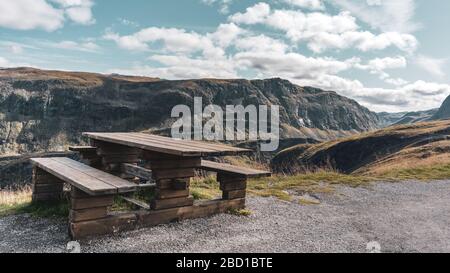 Holzbank, norwegische Berge Rest Aussichtspunkt. Reisen sie skandinavischen Naturpark. Blick auf das Tal von Rastplatz in der Nähe der Fahrstraße. Farbkorrektur Stockfoto