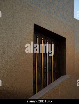 Ein Detail einer Tür und Gold geflieste Wand in der Abendsonne in der Goldenen Moschee im Katara Kulturdorf in Doha, Katar. Stockfoto