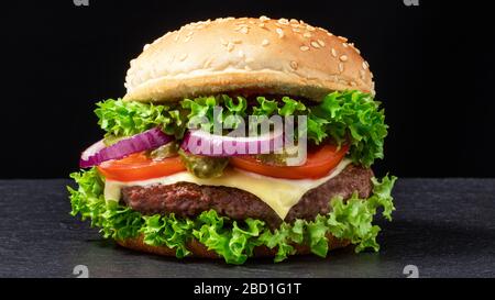 Frischer, leckerer Rinderburger auf dunklem Hintergrund. Stockfoto