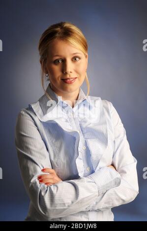 Das Porträt der schön schimmelenden Frau in blauem Hemd auf grauem Hintergrund Stockfoto