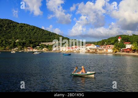 Deshaies Waterfront, Paar im Ruderboot, Tod in Paradise Location, Saint Marie, Basse Terre, Guadeloupe, Leeward Islands, Karibik Stockfoto