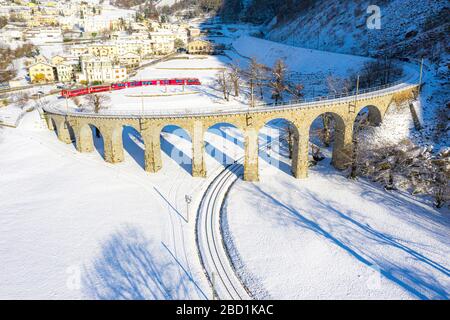 Bernina Express führt über das spiralförmige Viadukt von Brusio, UNESCO-Weltkulturerbe, Valposchiavo, Kanton Graubünden, Schweiz Stockfoto