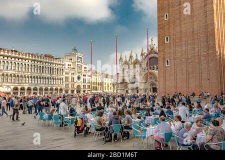 Leute, die draußen sitzen, genießen Kaffee und Getränke auf dem Markusplatz in Venedig Caffè Stockfoto