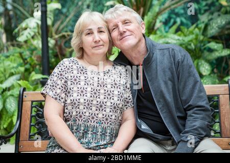 Fröhliches und lächelndes Familienporträt mit Mann und Frau, das auf der Wange sitzt, um sich zu überwehen. Kaukasische Menschen Stockfoto