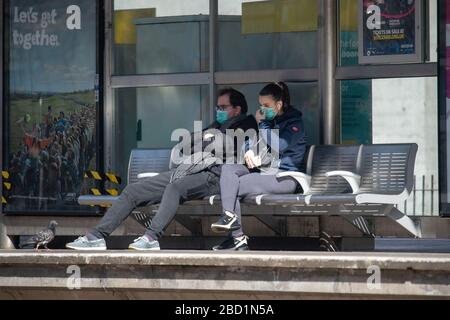 Manchester, Großbritannien. April 2020. Ein paar Gesichtsmasken warten am Montag, den 6. April 2020, auf eine Straßenbahn an der Metrolink-Haltestelle in Piccadilly Gardens, Manchester City Centre. (Credit: Pat Scaasi/MI News) Credit: MI News & Sport /Alamy Live News Stockfoto