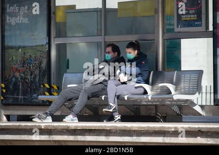 Manchester, Großbritannien. April 2020. Ein paar Gesichtsmasken warten am Montag, den 6. April 2020, auf eine Straßenbahn an der Metrolink-Haltestelle in Piccadilly Gardens, Manchester City Centre. (Credit: Pat Scaasi/MI News) Credit: MI News & Sport /Alamy Live News Stockfoto