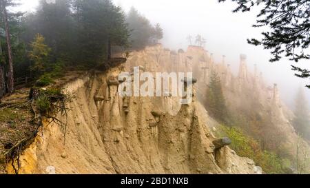 Erdpyramiden und Wälder im Herbstnebel Perca (Percha), Provinz Bolzano, Südtirol, Italien, Europa Stockfoto