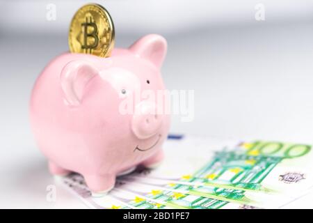 Bitcoin Sparschwein auf weißem Hintergrund mit EU-Euro-Scheine isoliert Stockfoto
